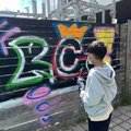 Ein Schüler steht vor einem Graffiti mit dem Schriftzug "RC!"