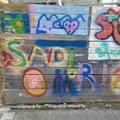 Verschiedene bunte Graffitis auf einem Bauzaun