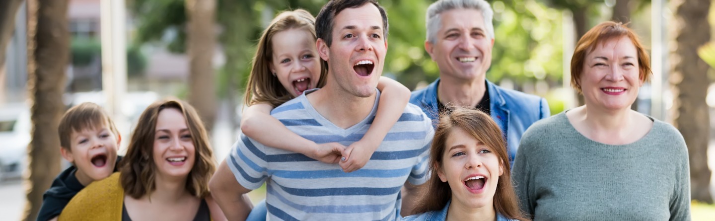 Header: Eine Familie mit drei Kindern, Eltern und Großeltern sind gemeinsam draußen unterwegs. 