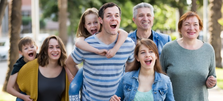 Header: Eine Familie mit drei Kindern, Eltern und Großeltern sind gemeinsam draußen unterwegs. 