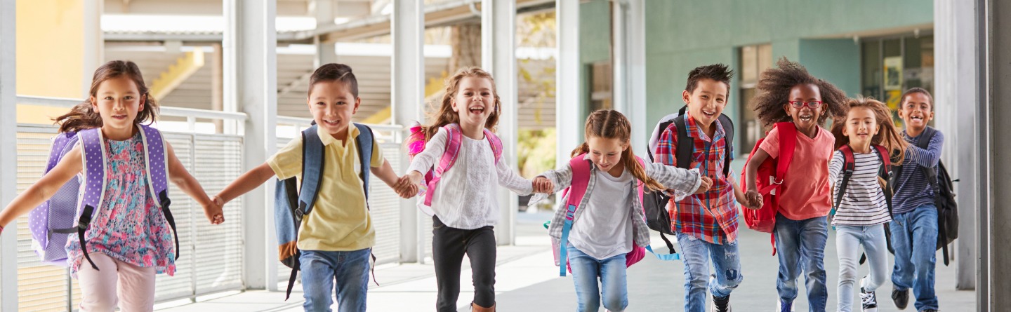 Schulkinder rennen im Gang einer Schule.