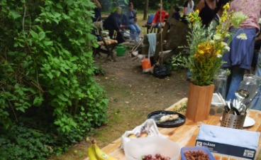 News-Foto: Gedeckter Biergarten-Tisch im Grünen mit Schul-Gruppe im Hintergrund