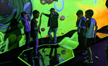 Ferienprogramm des KoGa Horts News-Foto: Kinder beim Schwarzlicht-Minigolf spielen