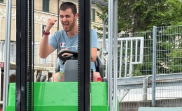 Gaberlstablerprüfung MAut Junger Mann fährt einen Gabelstabler und macht mit dem rechten Arm eine Erfolgsgeste